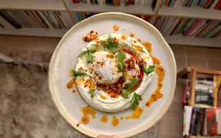 Turkish eggs with garlic yoghurt, poached eggs, and Aleppo chilli ghee, served with fresh herbs