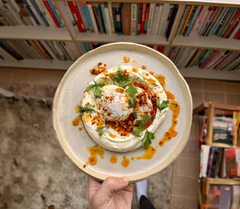 Turkish eggs with garlic yoghurt, poached eggs, and Aleppo chilli ghee, served with fresh herbs