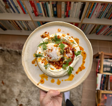 Turkish eggs with garlic yoghurt, poached eggs, and Aleppo chilli ghee, served with fresh herbs