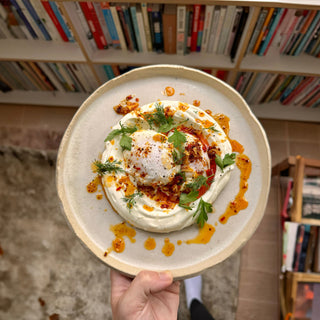 Turkish eggs with garlic yoghurt, poached eggs, and Aleppo chilli ghee, served with fresh herbs